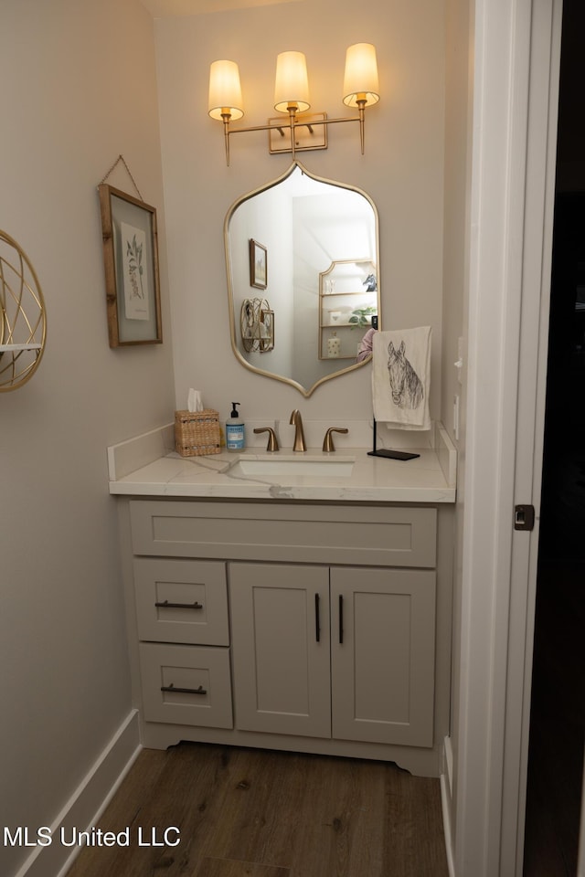 bathroom featuring wood finished floors, vanity, and baseboards