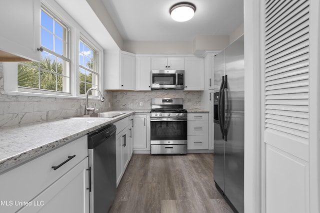 157 Saint Charles Ave, Biloxi, MS 39530 - kitchen with stainless steel appliances, backsplash, white cabinets, dark wood-type flooring, and light stone counters
