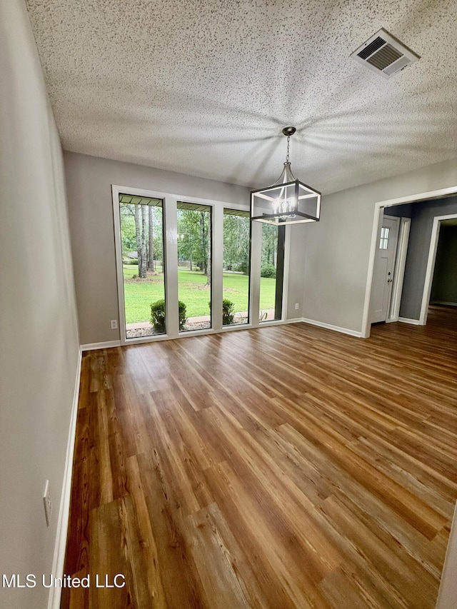 119 Chinquipin Ln, Florence, MS 39073 - unfurnished dining area featuring a chandelier, wood finished floors, and a textured ceiling