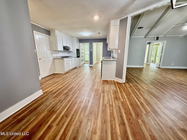 119 Chinquipin Ln, Florence, MS 39073 - kitchen with open floor plan, healthy amount of natural light, light wood finished floors, white cabinetry, and beam ceiling
