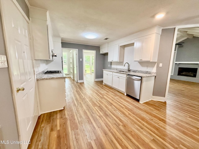 119 Chinquipin Ln, Florence, MS 39073 - kitchen with stainless steel appliances, light wood-style floors, white cabinetry, a brick fireplace, and light stone counters