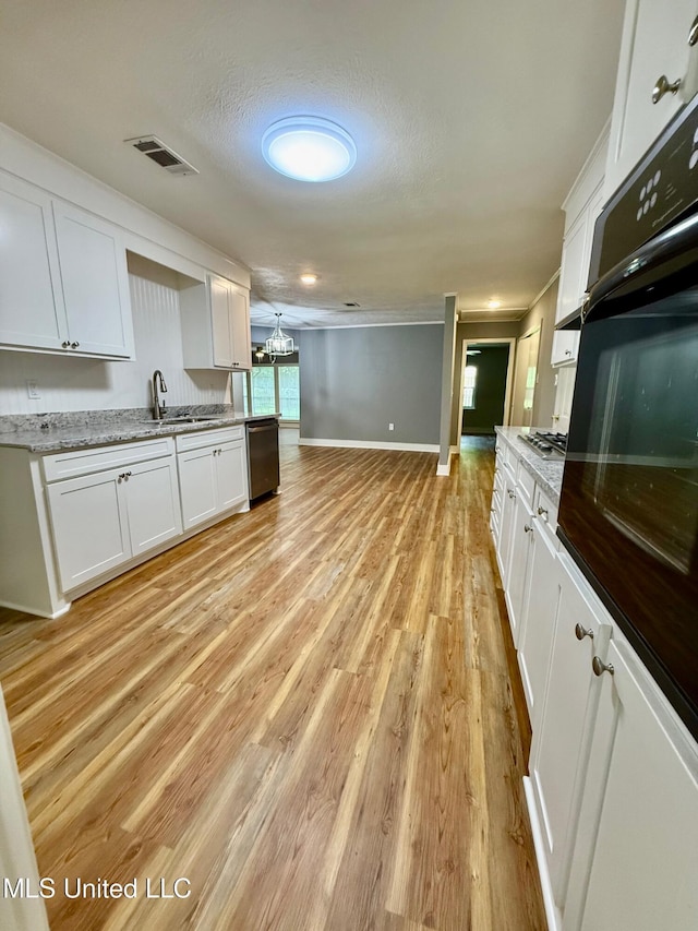119 Chinquipin Ln, Florence, MS 39073 - kitchen with appliances with stainless steel finishes, white cabinets, light wood-style floors, ornamental molding, and a chandelier