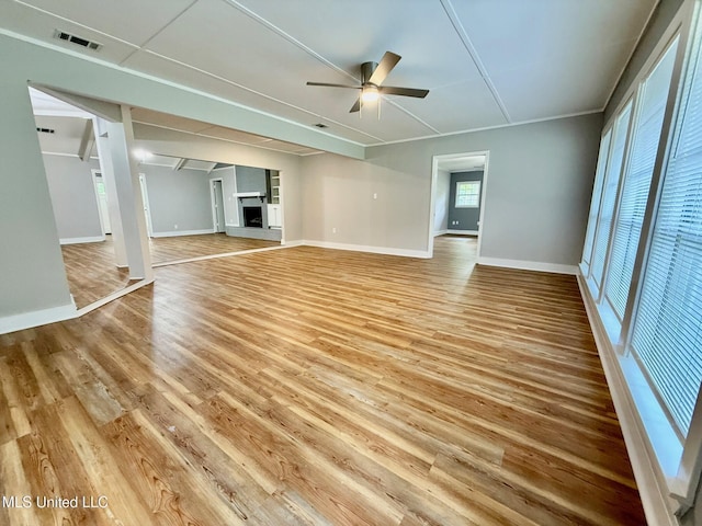 119 Chinquipin Ln, Florence, MS 39073 - unfurnished living room featuring a ceiling fan, light wood-style floors, and a fireplace with raised hearth