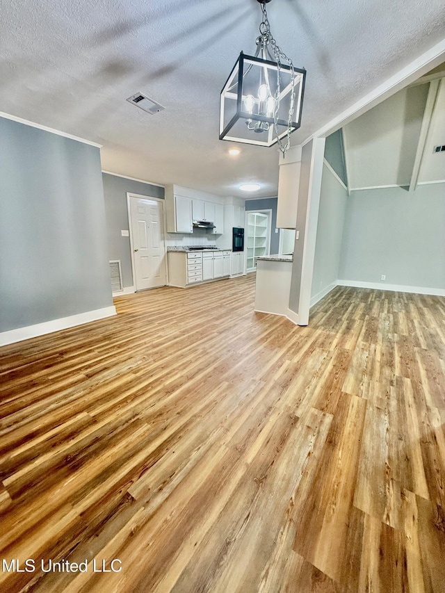 119 Chinquipin Ln, Florence, MS 39073 - unfurnished living room featuring a textured ceiling, light wood-style floors, and a chandelier