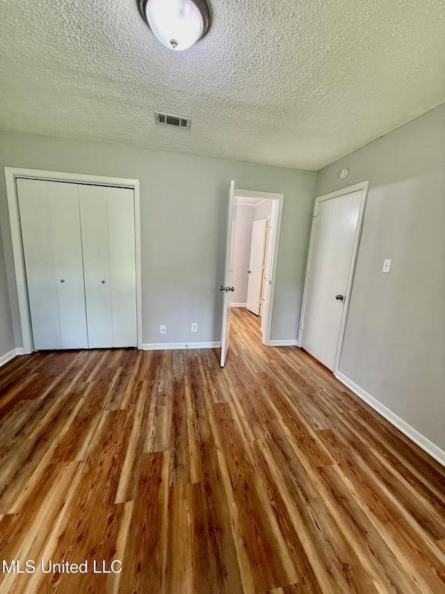 119 Chinquipin Ln, Florence, MS 39073 - unfurnished bedroom with wood finished floors, a textured ceiling, and a closet