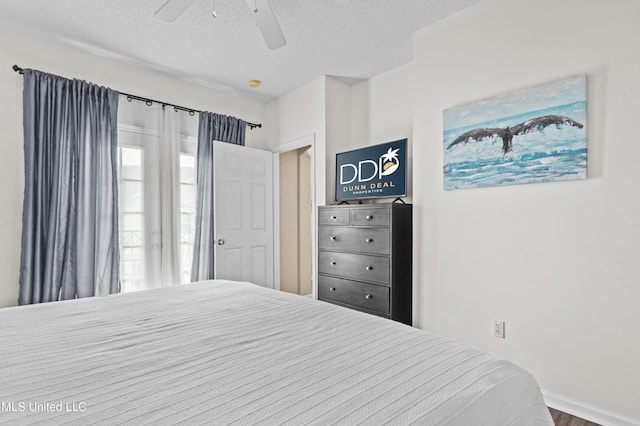 bedroom featuring baseboards, a ceiling fan, and a textured ceiling