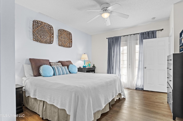 bedroom featuring a textured ceiling, wood finished floors, and a ceiling fan