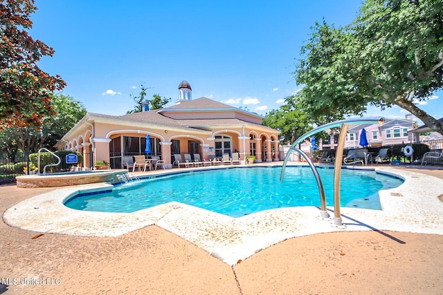 community pool featuring a patio area and fence