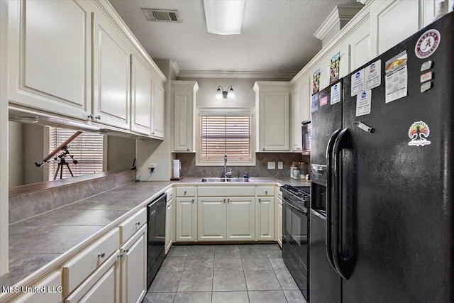 kitchen with sink, tile countertops, black appliances, and white cabinets