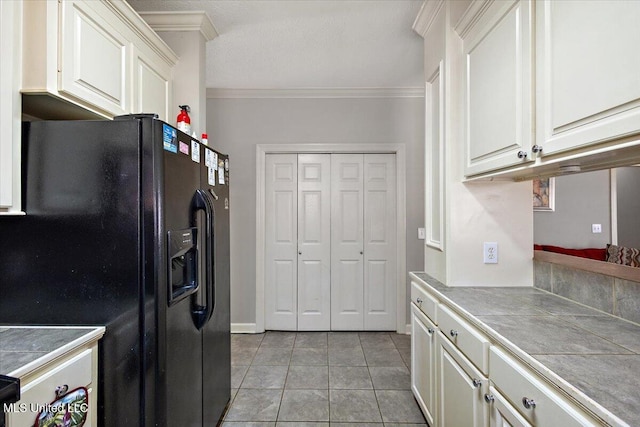 kitchen featuring light tile patterned floors, white cabinetry, tile counters, ornamental molding, and black refrigerator with ice dispenser