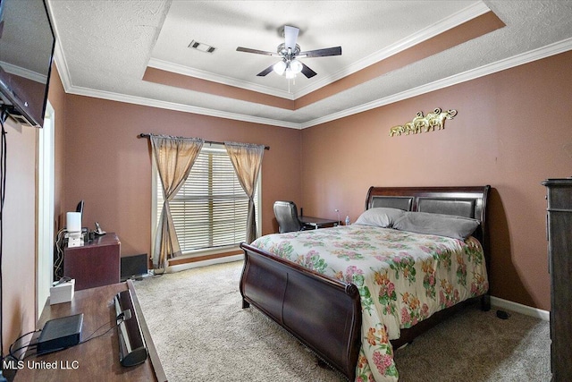 bedroom featuring a raised ceiling, crown molding, carpet floors, and a textured ceiling