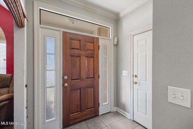 entryway with ornamental molding and light tile patterned floors