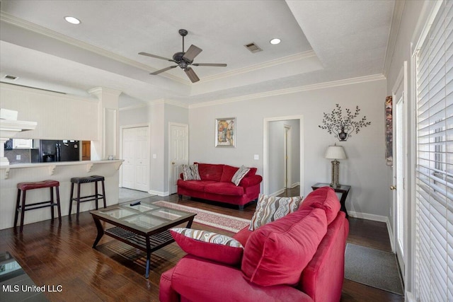 living room featuring a raised ceiling, crown molding, dark hardwood / wood-style floors, and ceiling fan