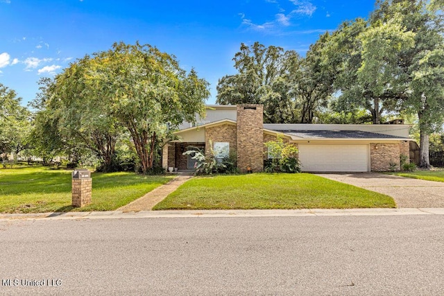 mid-century modern home with brick siding, an attached garage, concrete driveway, and a front lawn