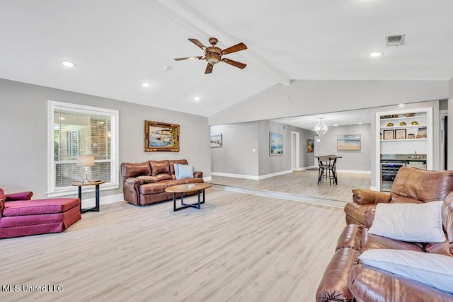 living area featuring a ceiling fan, baseboards, vaulted ceiling with beams, light wood-style floors, and a dry bar