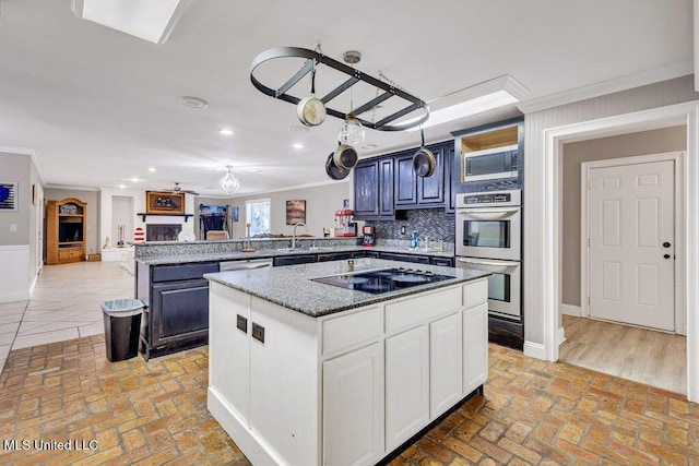 kitchen with crown molding, a center island, brick floor, and stainless steel appliances