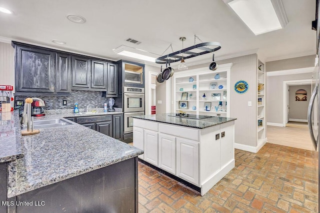 kitchen featuring visible vents, brick floor, black electric cooktop, and a sink