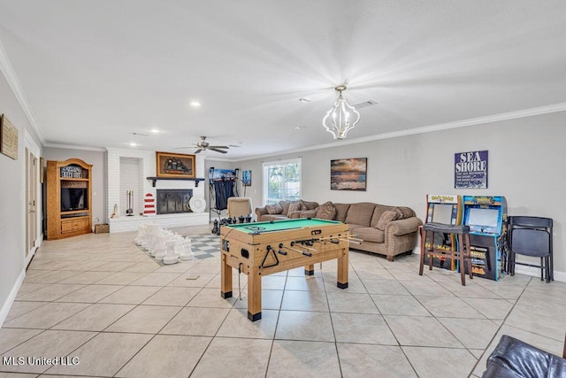 game room with light tile patterned flooring, a brick fireplace, and crown molding