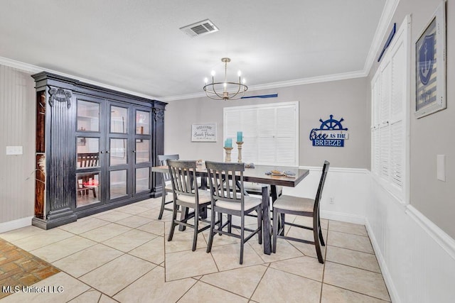 dining space with light tile patterned floors, baseboards, visible vents, an inviting chandelier, and crown molding