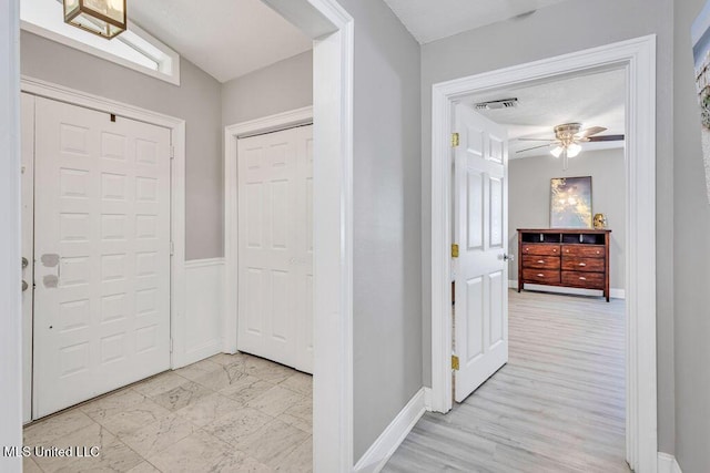 corridor featuring visible vents and baseboards