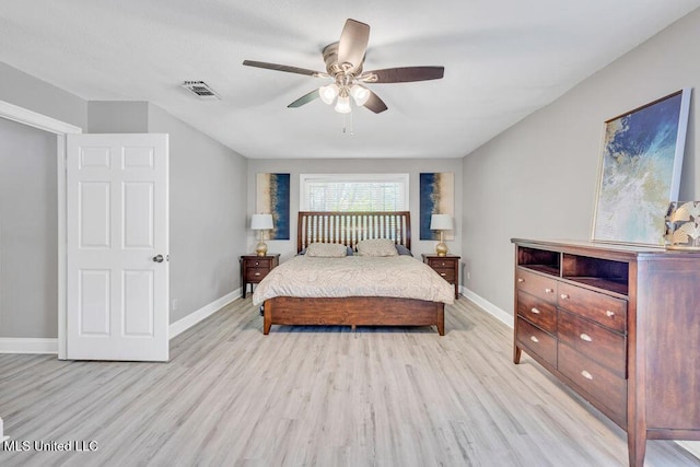 bedroom with visible vents, baseboards, and wood finished floors