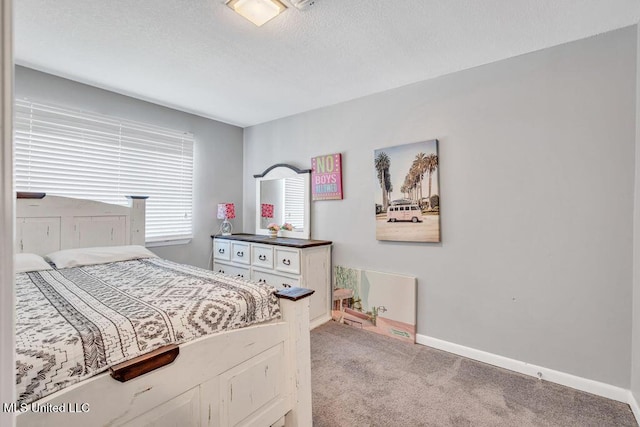 bedroom featuring a textured ceiling, baseboards, and light carpet