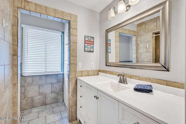 full bath with tile walls and vanity