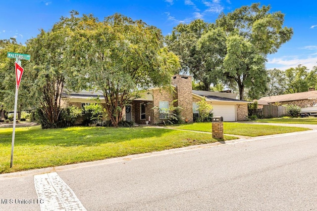 view of front of property featuring brick siding, a front lawn, fence, and a garage