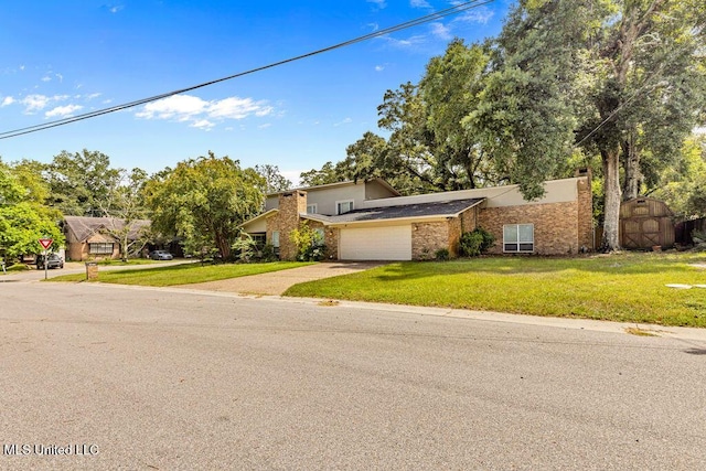 view of front of property featuring a garage, driveway, a front yard, and a shed