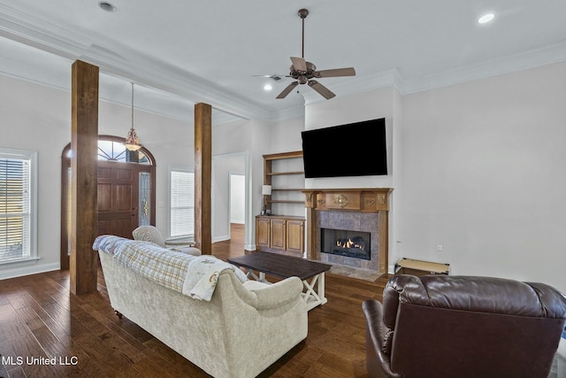 living room with ceiling fan, ornamental molding, a fireplace, and dark hardwood / wood-style flooring