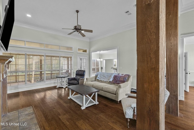 living room featuring dark wood-type flooring, ornamental molding, and ceiling fan