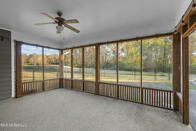 unfurnished sunroom featuring ceiling fan