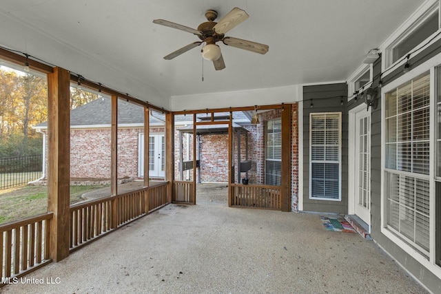 unfurnished sunroom with ceiling fan