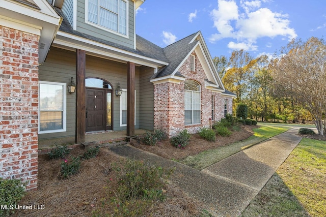 property entrance featuring a lawn