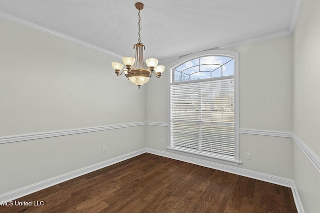 empty room featuring hardwood / wood-style flooring, crown molding, and an inviting chandelier