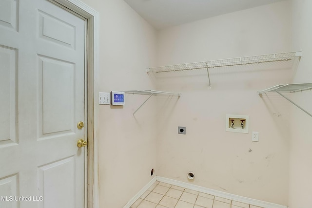 clothes washing area with washer hookup, light tile patterned floors, electric dryer hookup, laundry area, and baseboards