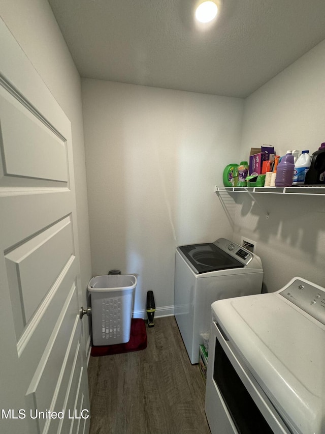 washroom with dark hardwood / wood-style flooring, washer and clothes dryer, and a textured ceiling