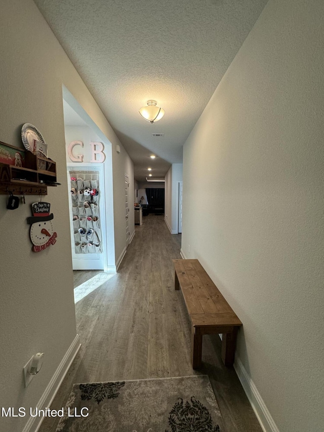 hall with a textured ceiling and hardwood / wood-style flooring