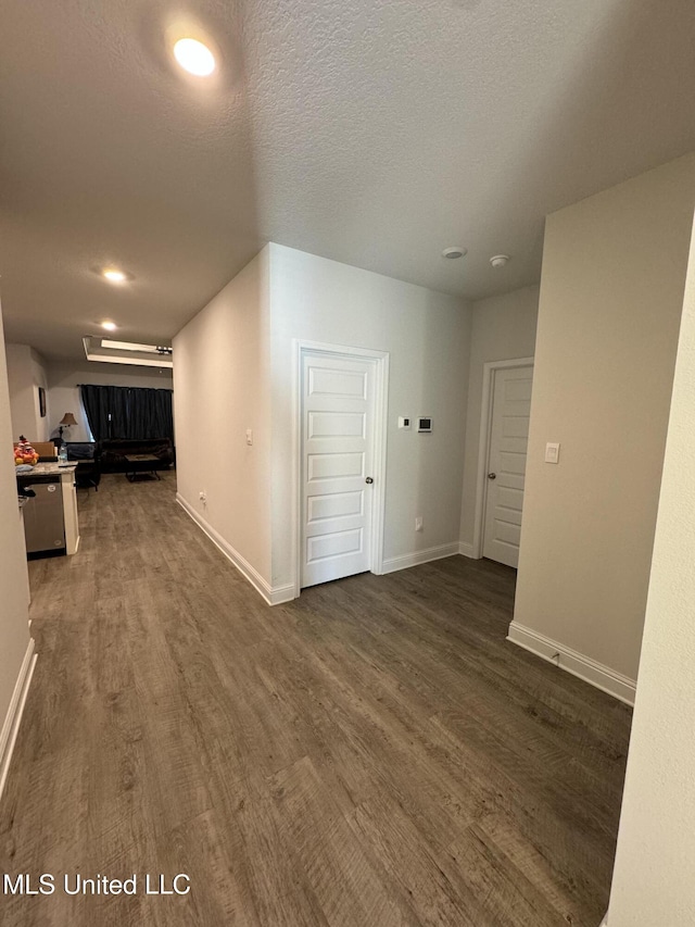 corridor featuring dark hardwood / wood-style floors and a textured ceiling