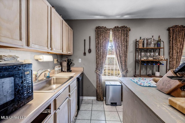 kitchen featuring light brown cabinetry, sink, light tile patterned floors, and black appliances