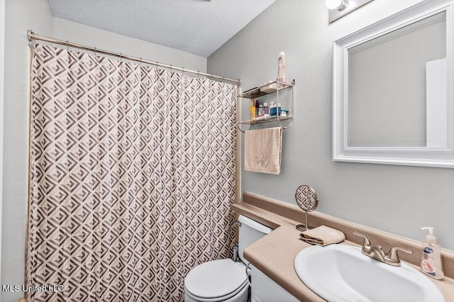 bathroom with vanity, toilet, and a textured ceiling