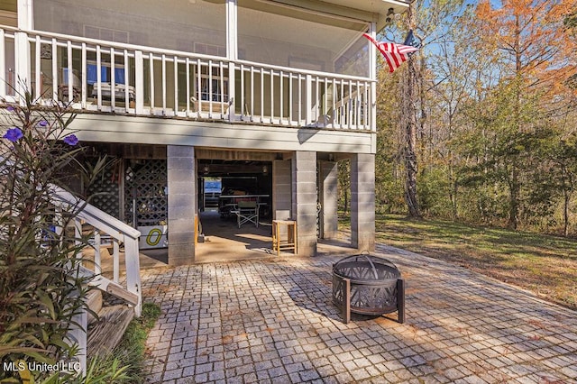 view of patio featuring a balcony and an outdoor fire pit