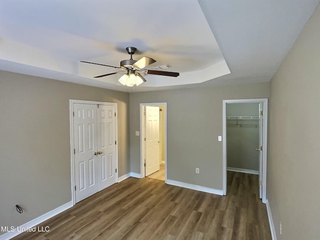 1204 Dorothy St, Ocean Springs, MS 39564 - unfurnished bedroom with a closet, wood finished floors, baseboards, a tray ceiling, and ceiling fan