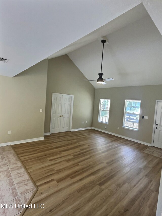 1204 Dorothy St, Ocean Springs, MS 39564 - unfurnished living room featuring a ceiling fan, baseboards, wood finished floors, and high vaulted ceiling