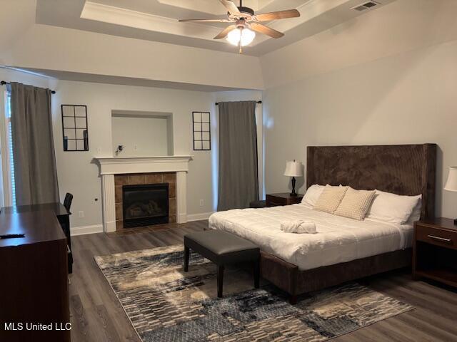 220 Forked Creek Pkwy, Hernando, MS 38632 - bedroom featuring wood finished floors, a tiled fireplace, a raised ceiling, and baseboards