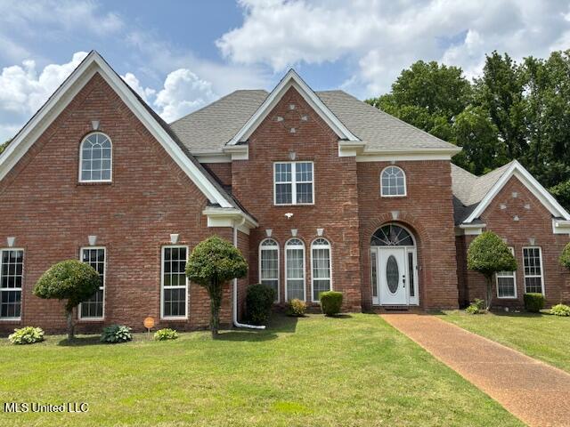 220 Forked Creek Pkwy, Hernando, MS 38632 - colonial-style house featuring a front yard, brick siding, and a shingled roof