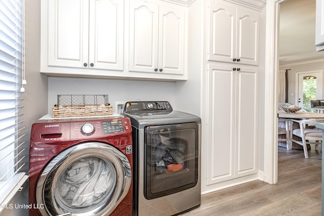 clothes washing area with crown molding, cabinets, separate washer and dryer, and light hardwood / wood-style floors