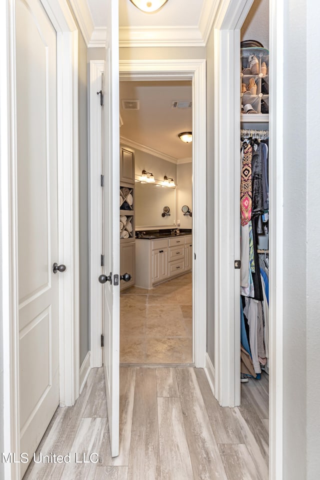 corridor with crown molding and light hardwood / wood-style floors