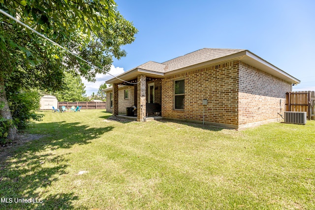 rear view of property with a lawn and central AC unit