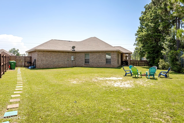 rear view of house featuring a lawn and a fire pit